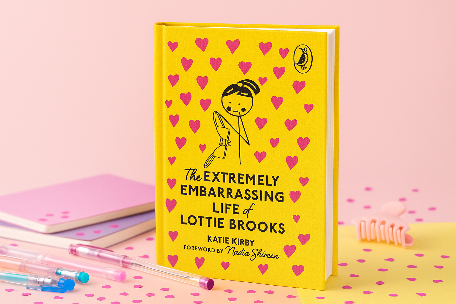 Book titled 'The Extremely Embarrassing Life of Lottie Brooks' with a yellow cover and pink hearts on a pink background.